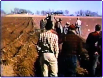 Farmers watching farm equipment demonstration