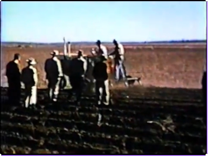 Farmers watching farm equipment demonstration