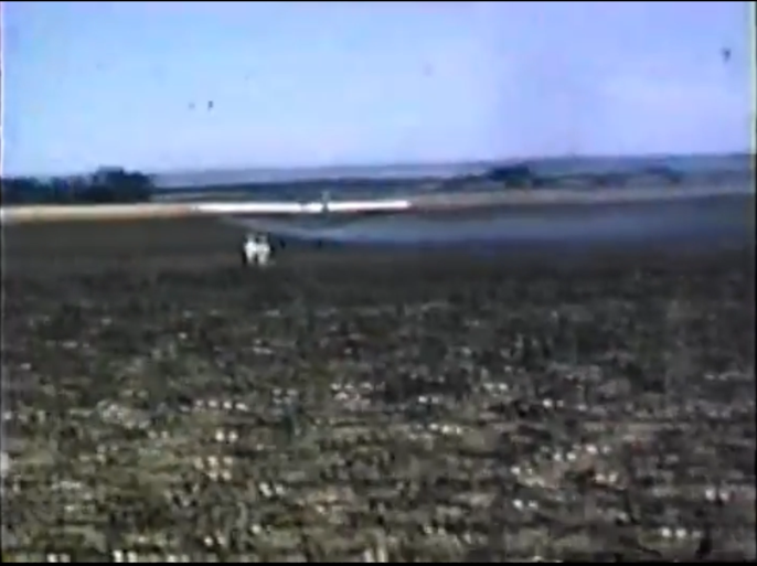 Crop spraying airplane, flagger in the field